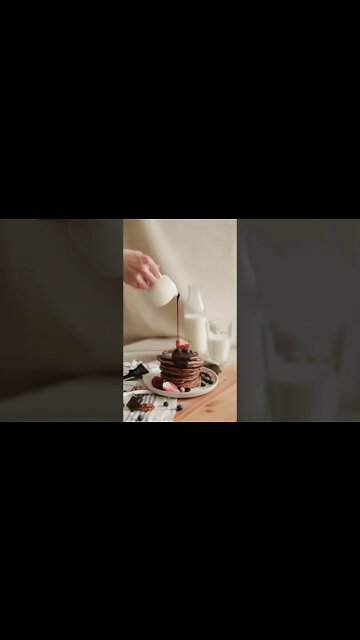 A Person Pouring Chocolate Syrup on Pancakes