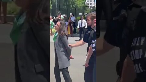 AOC pretends to be handcuffed as she's escorted away from SCOTUS by police