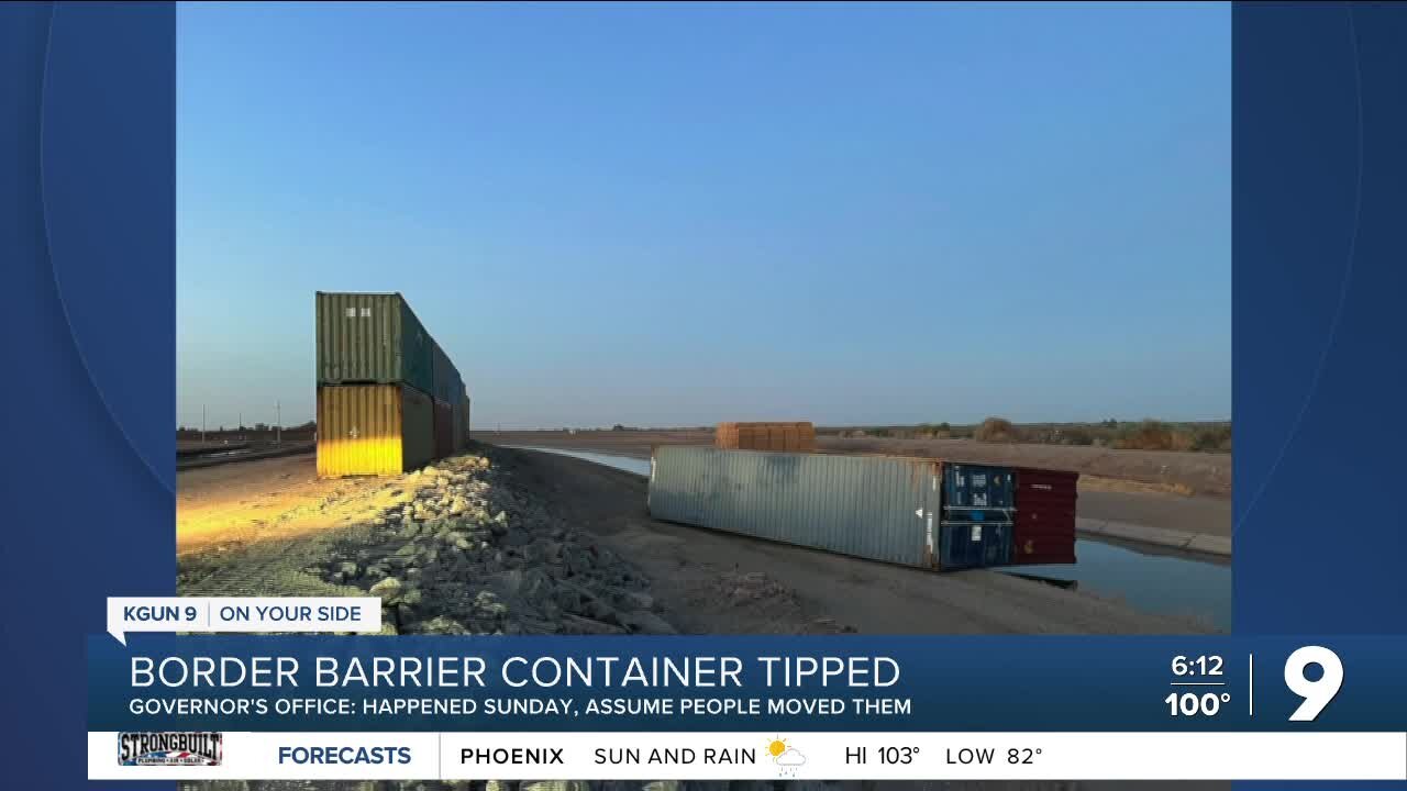 Two toppled border wall shipping containers now welded in place