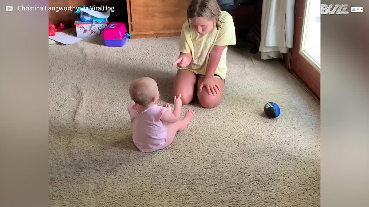Une petite fille et un bébé se disputent d'une adorable façon