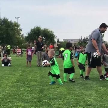 Boy Carries Soccer Ball To Goal