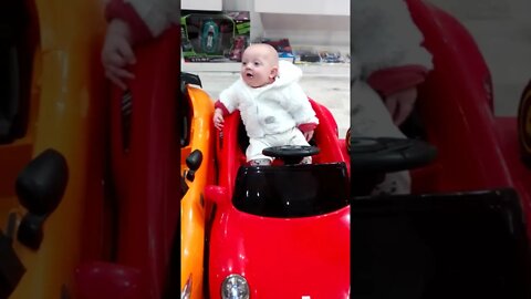 Cute Baby Boy Sitting In Toy Car