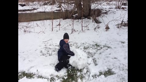 Boy Faces off with Big Snowball