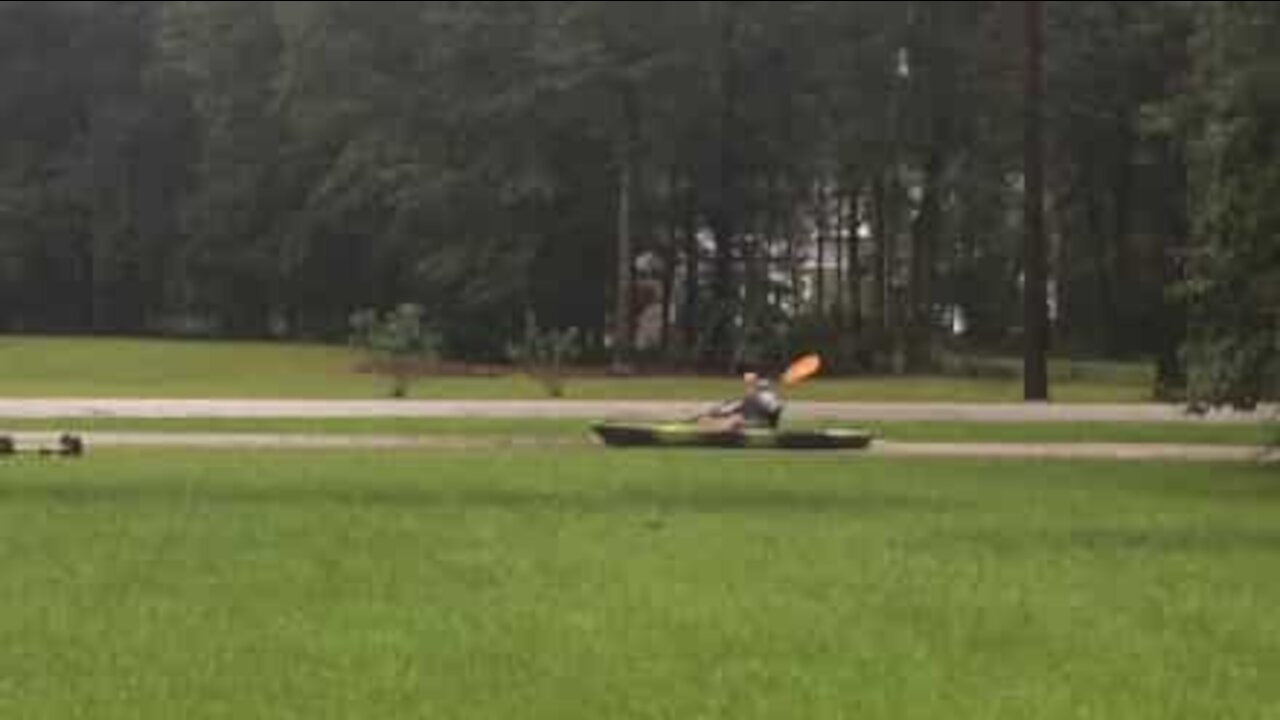 Man kayaks floodwater in garden