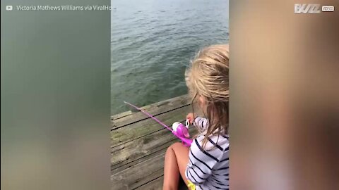 Une fillette ravie d'avoir pêché son premier poisson