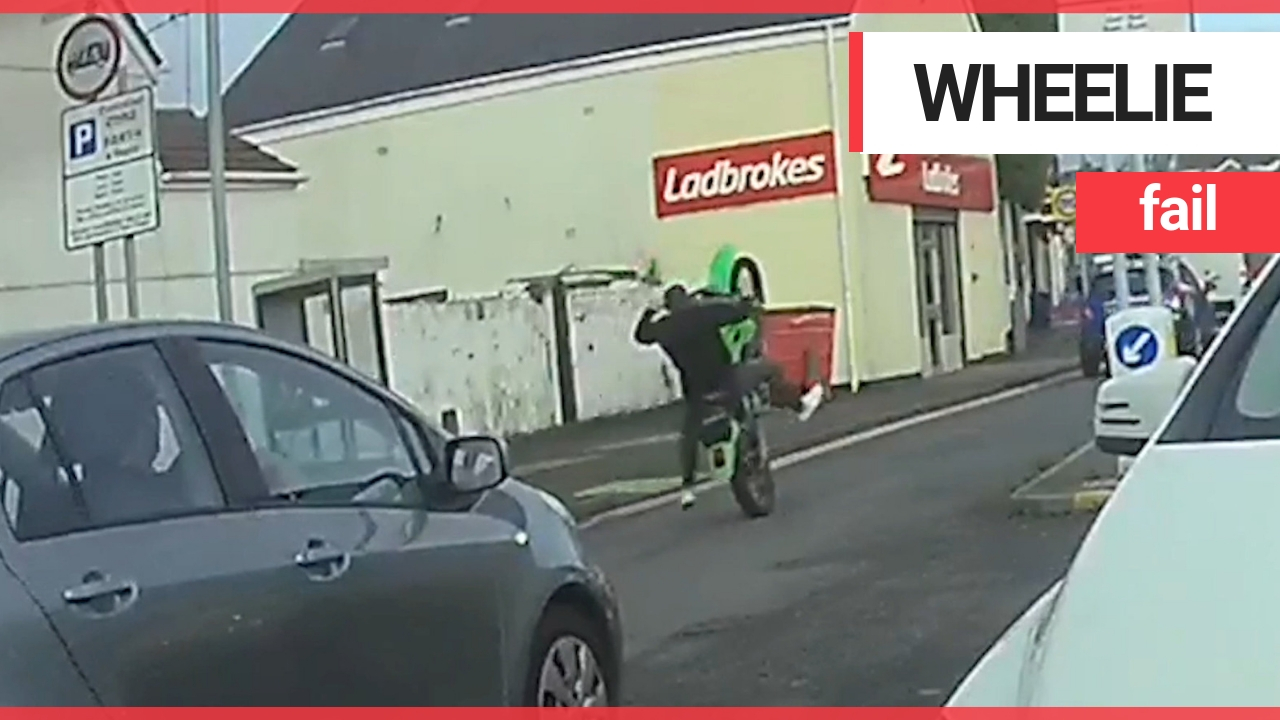 Idiot motorist falls off motorbike without any protective gear after attempting a wheelie