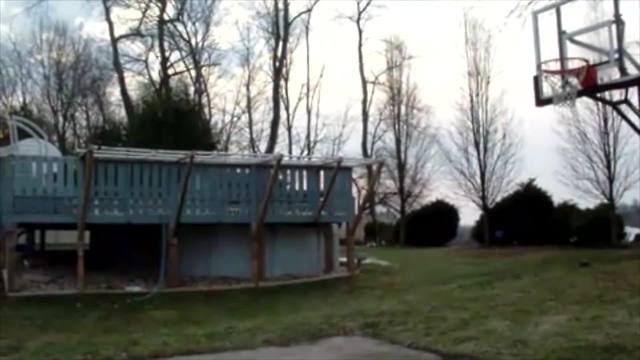 Several Young Men Attempt To Score A Trick Basketball Shot, But Only One Succeeds