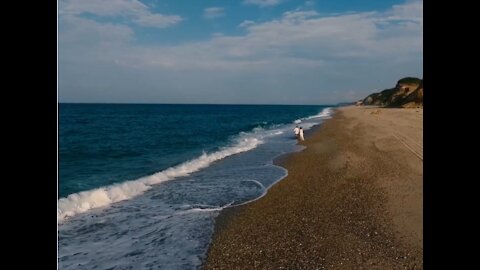 Drone Footage Of A Couple Holding Hands Walking In The Beach