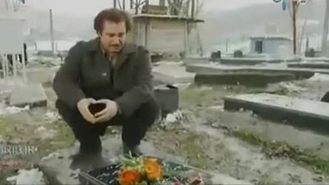 Man's grief as he visits mother's grave in cemetery