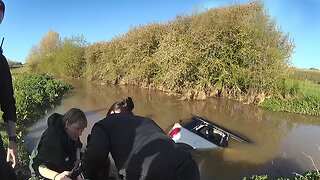 Police officers save woman stranded in her car from flooded ford