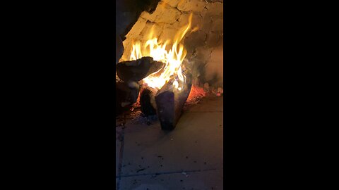 An old rock oven burning wood