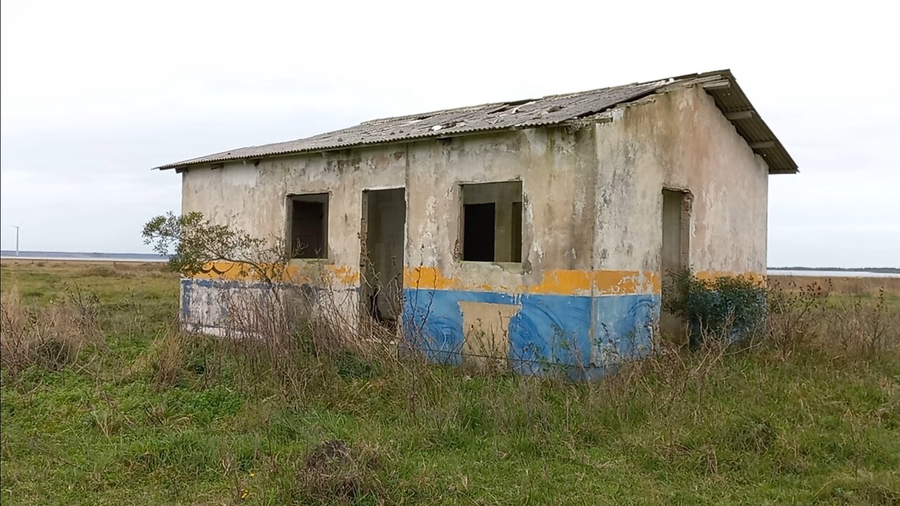 casa abandonada num campo próximo de uma lagoa