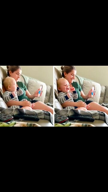 Baby watching a video next to his mother, he laughs because he thinks it's very funny the video