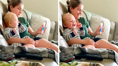 Baby watching a video next to his mother, he laughs because he thinks it's very funny the video