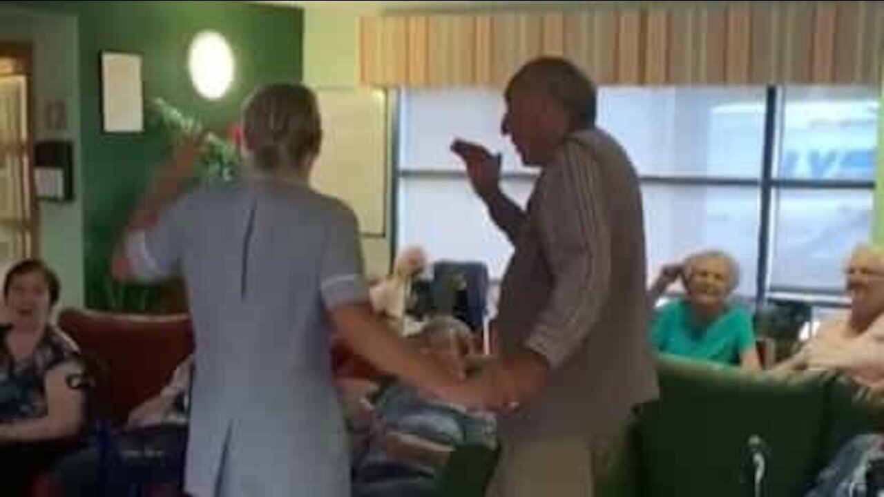 Une aide soignante et un pensionnaire entame une danse