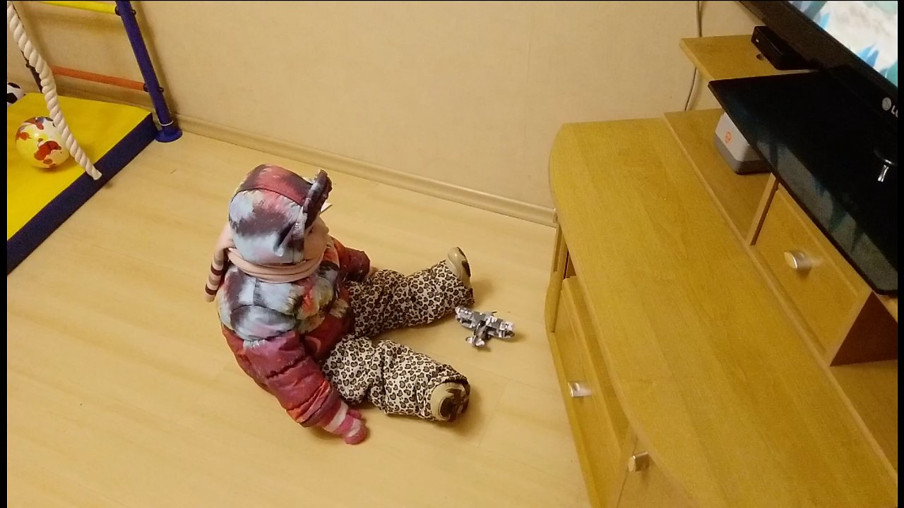 Funny kid didn't want to undress when she got home. Immediately turned on her favorite cartoon.