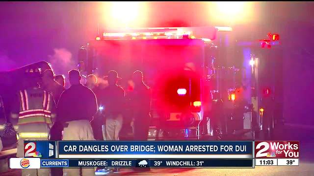 Woman arrested after car dangles off bridge