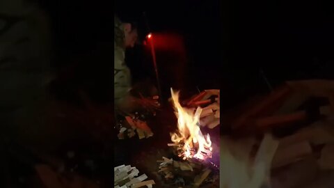 drying damp firewood around the campfire