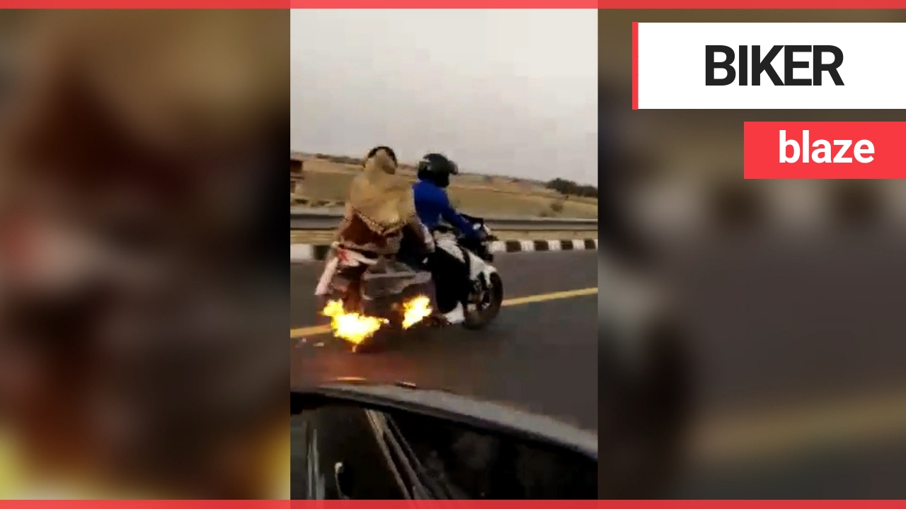 Hero driver saves motorbiker as he cruises down highway unaware that his bike is on fire