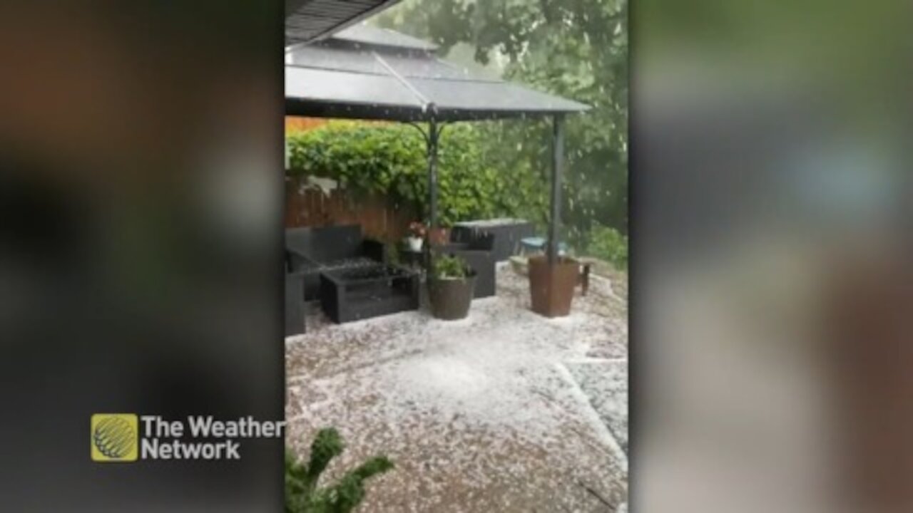 Hail piles up on the ground outside a house