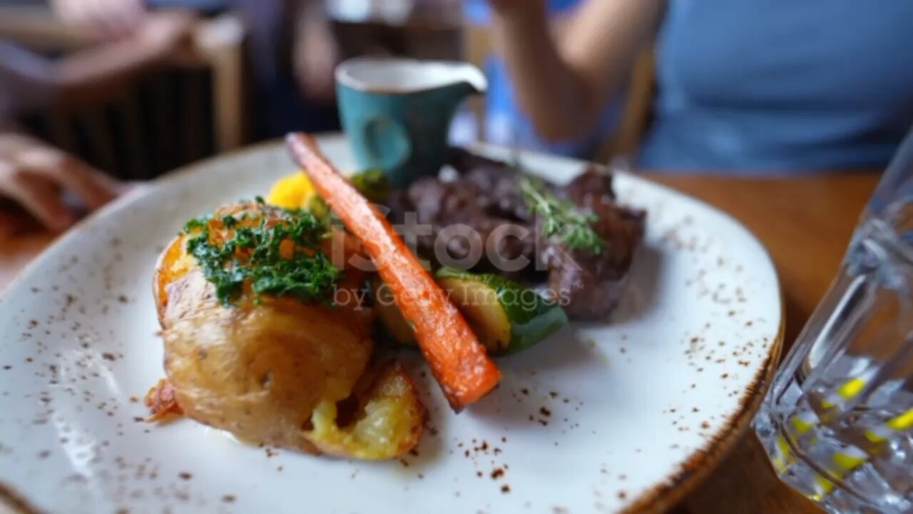 Gourmet food on plate at restaurant with people in