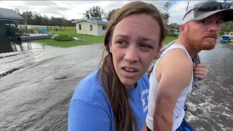 Neighbors help each other to safety as community blocked off by flood waters