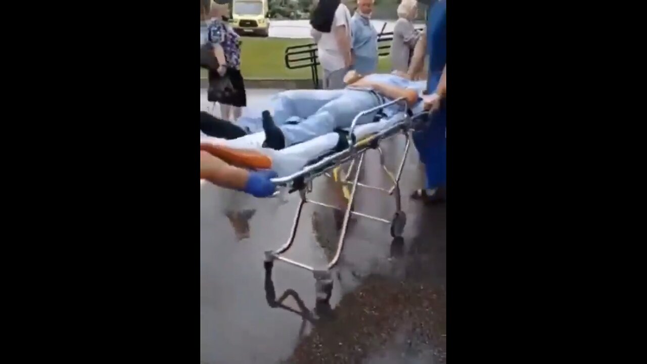 People wait in line to get a shot, while an injected person is carried away by ambulance!