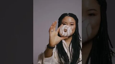 A Woman Covering her Eye while Holding a Donut