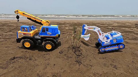 A convoy of excavator vehicles encircles the beachside