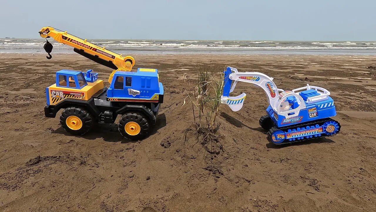 A convoy of excavator vehicles encircles the beachside