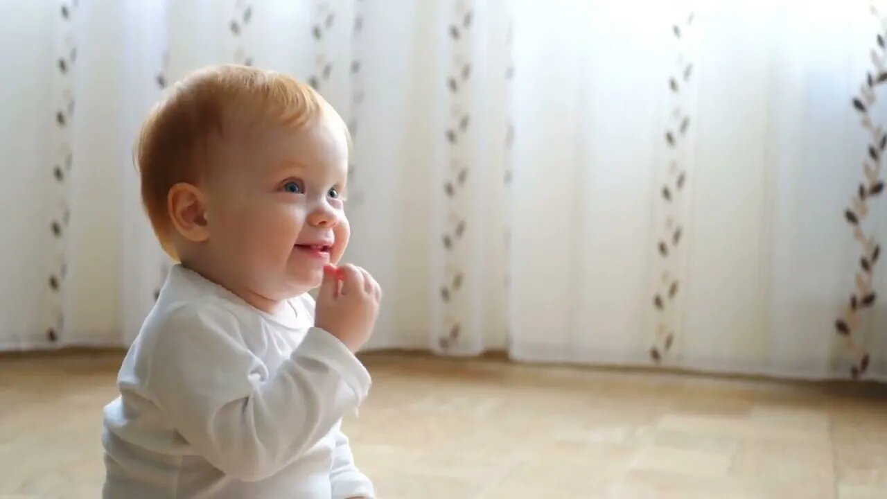 Redhead baby girl smiles and hugging a big bear toy