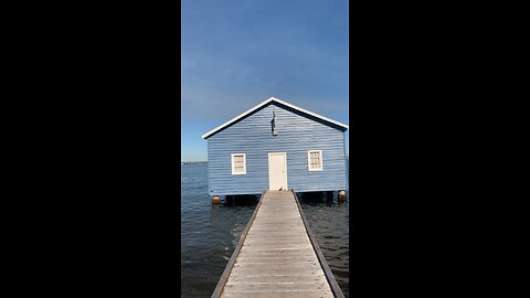 The blue boat house and its natural surroundings