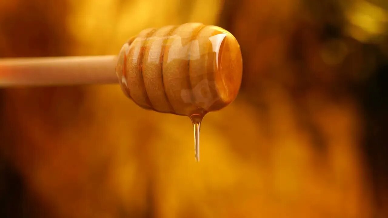Footage organic honey dripping from wooden honey spoon background24