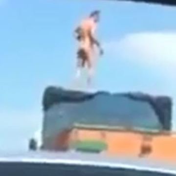 Man standing on a lorry in highway