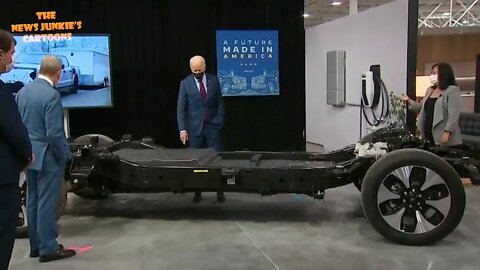 Fully vaccinated and heavily masked Biden examines an electric battery at a Ford plant.
