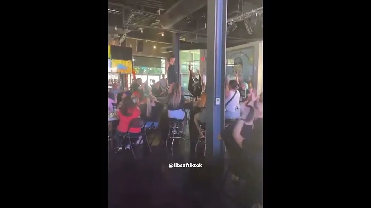 Drag queen leads a child in performing for the audience and collect tips at a drag show in Nebraska