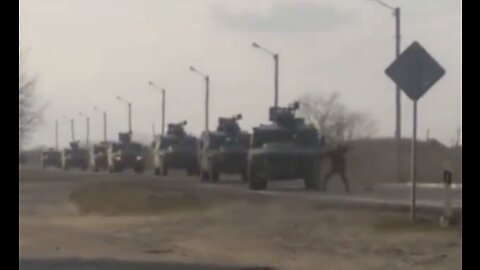 Ukrainian citizen attempting to block a large convoy of Russian vehicles