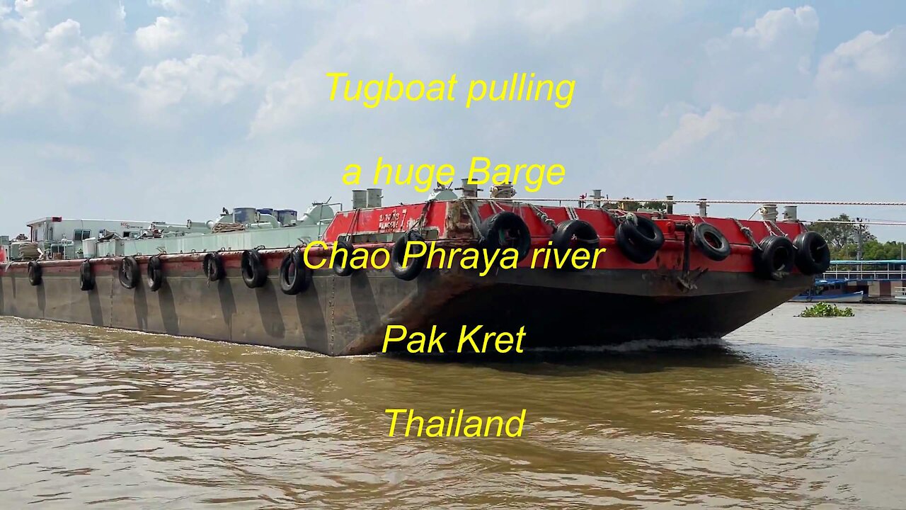 Tugboat pulling a Huge Barge at Chao Phraya river in Thailand