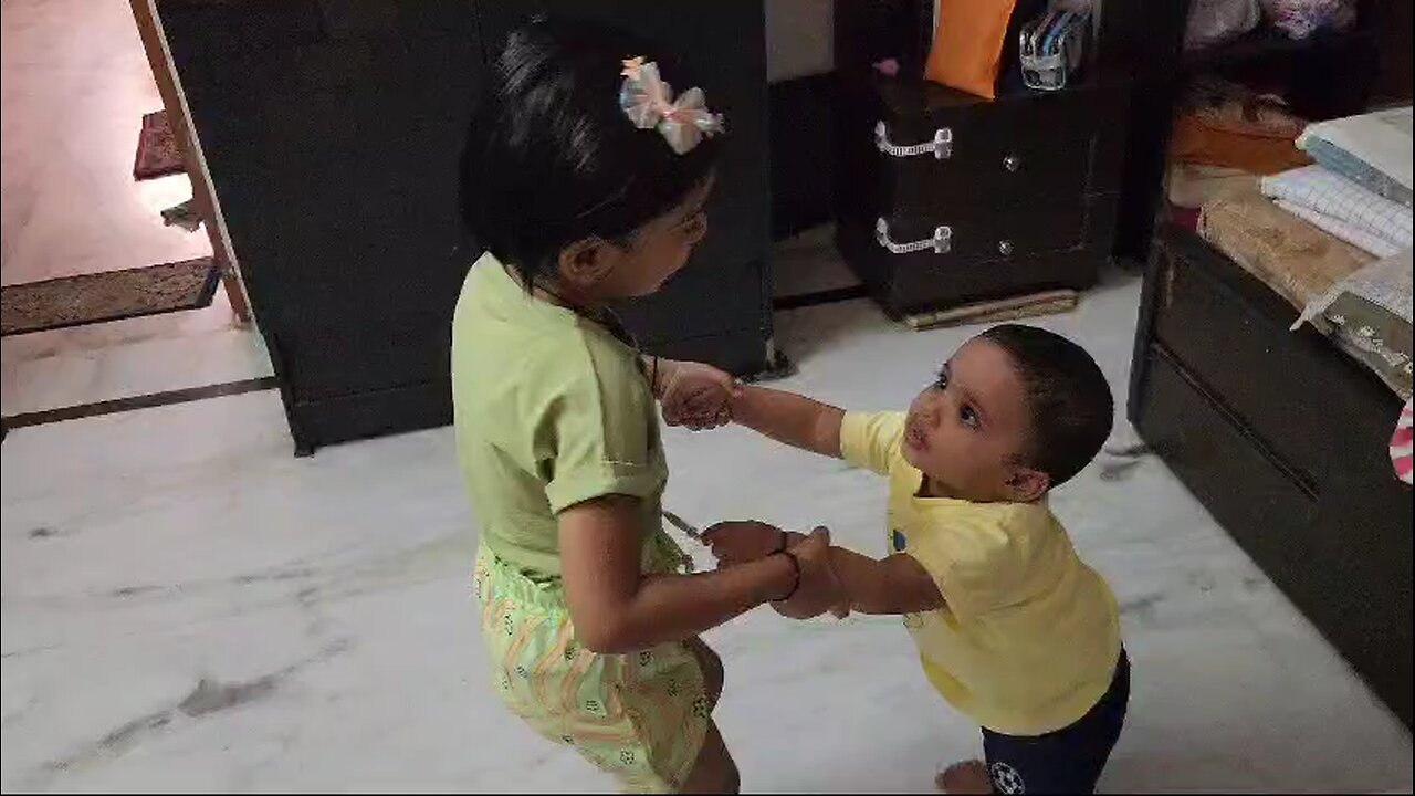 little sister helping litter brother for walking new steps