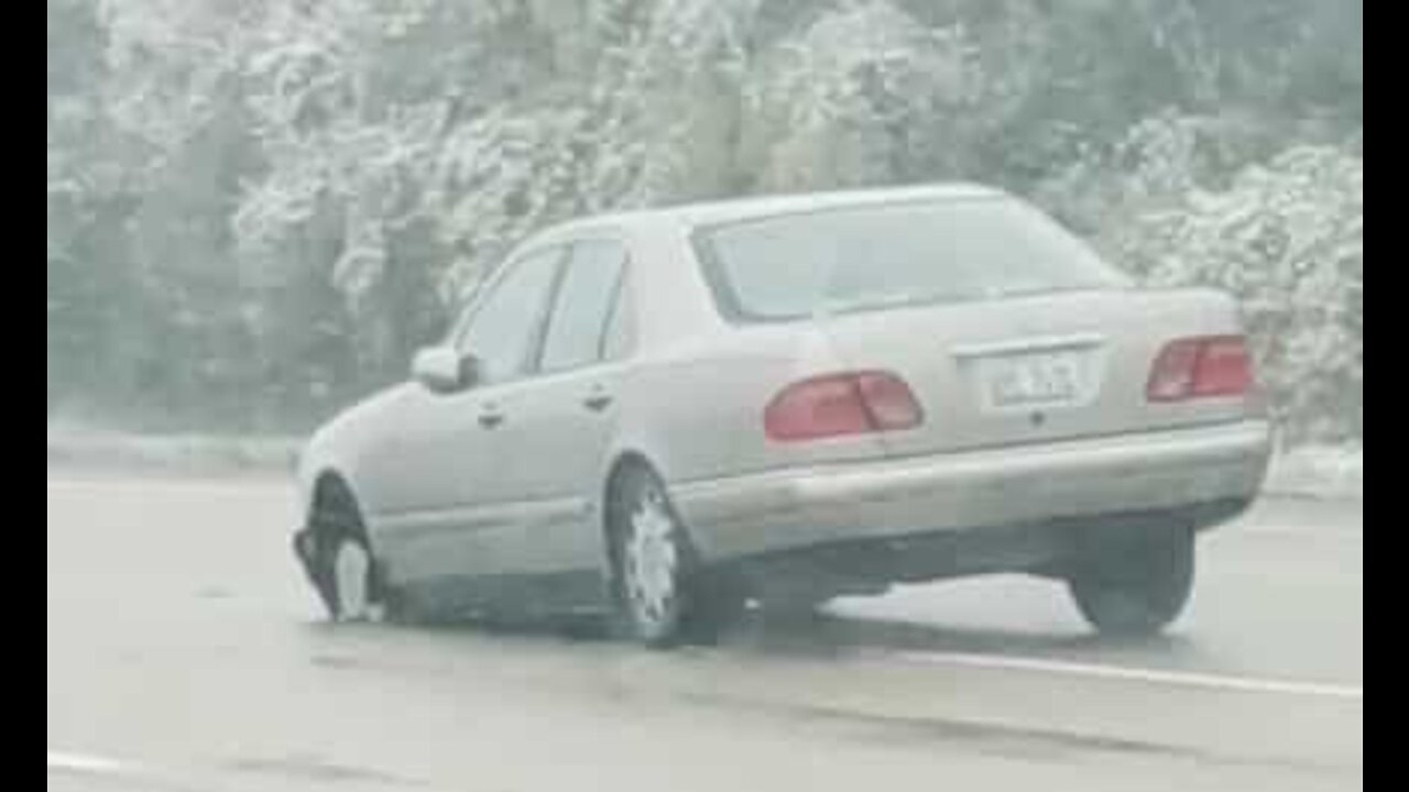 Il conduit sans pneu avant sous la pluie