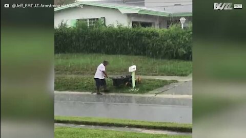 La pluie n'empêchera pas cet homme de tondre sa pelouse