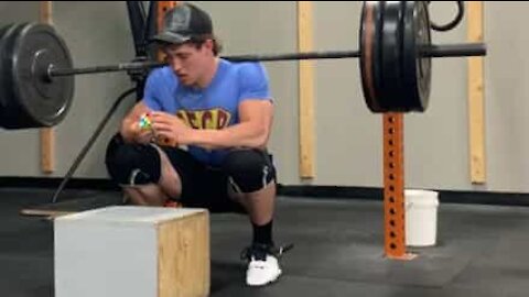 Cet homme résout un Rubik's Cube avec 124kg sur les épaules