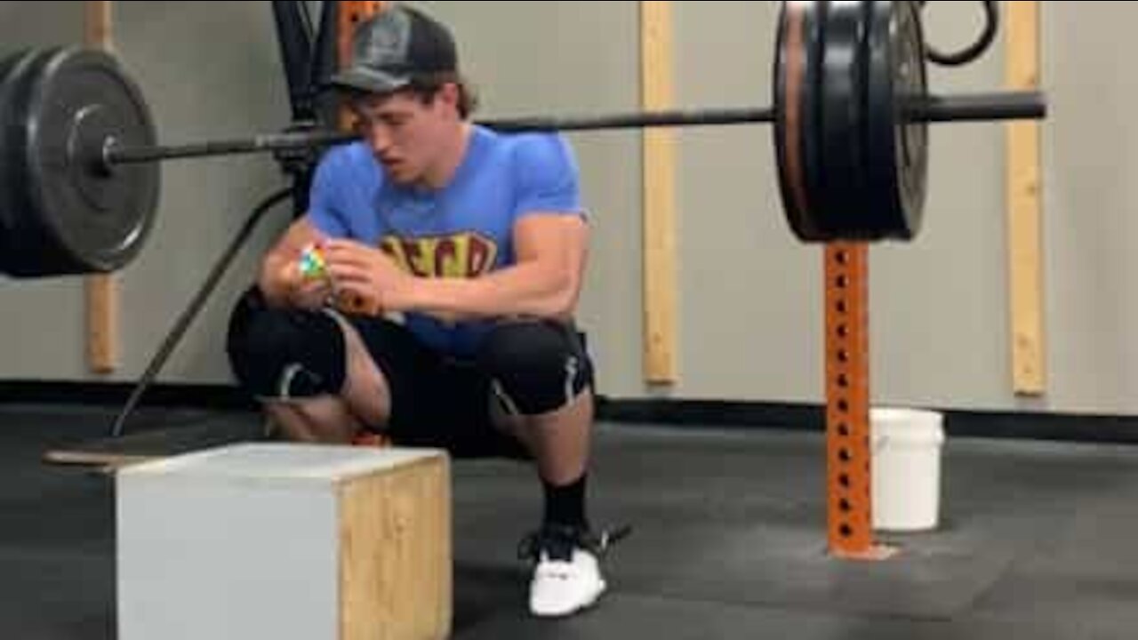 Cet homme résout un Rubik's Cube avec 124kg sur les épaules