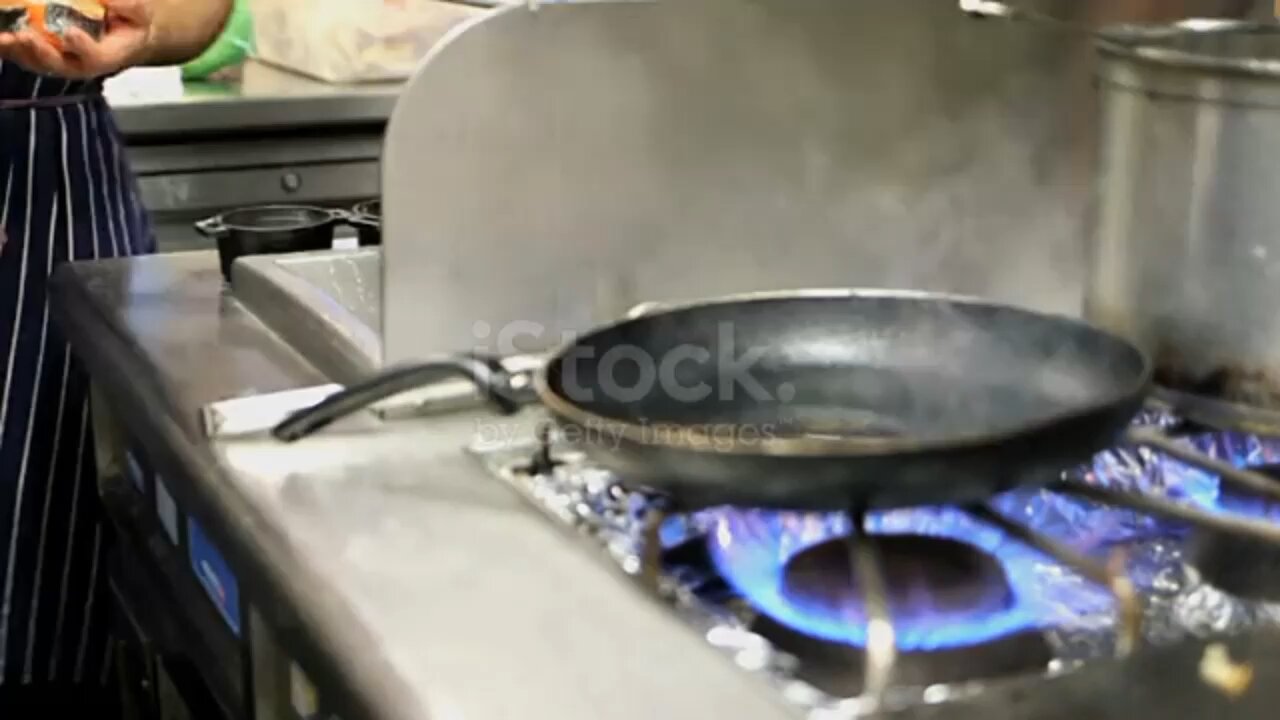 Chef cooking Salmon steaks in kitchen