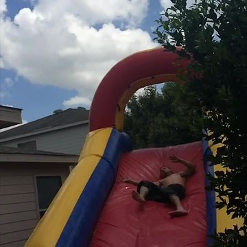 Man Leaps Off Roof Into Bounce Slide And Into A Tree