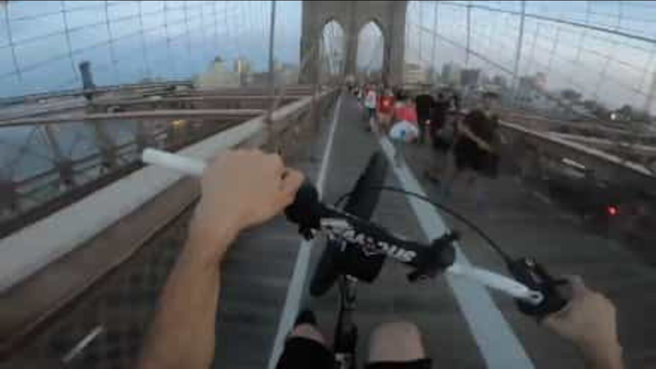 Jovem atravessa ponte de Brooklyn a fazer um cavalinho