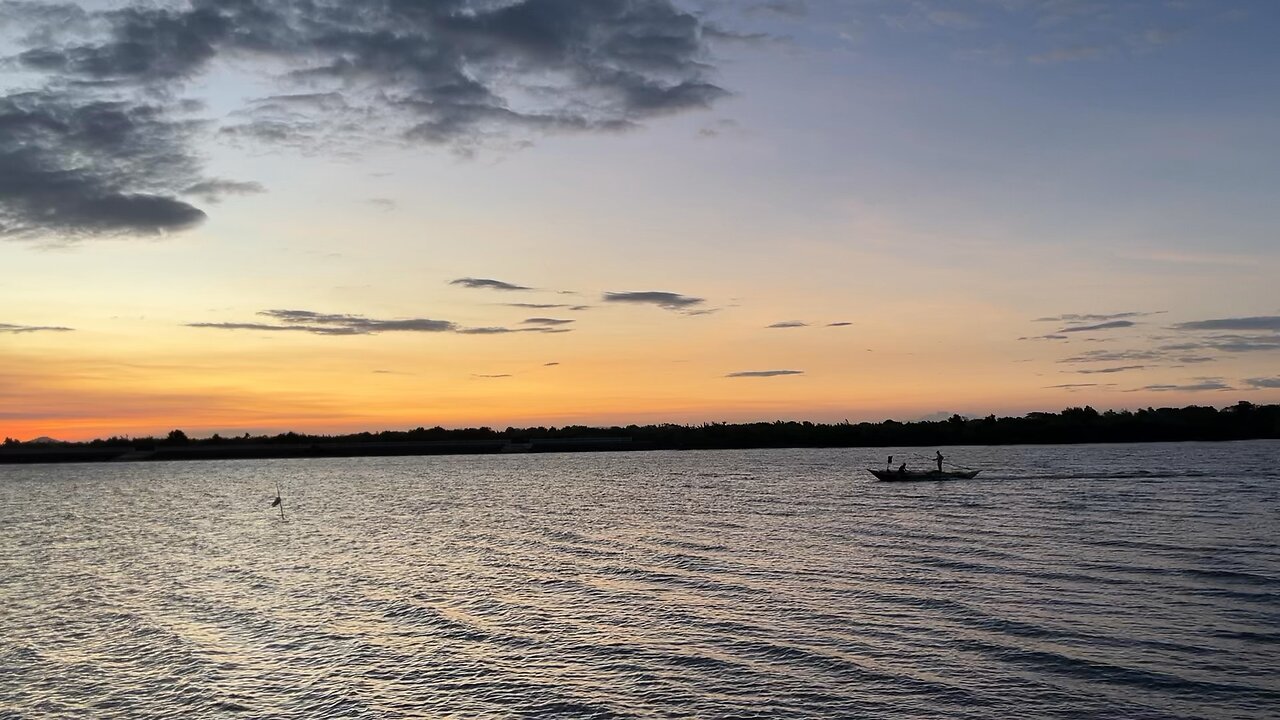 Serene Boat Ride Across a Sunset Sky