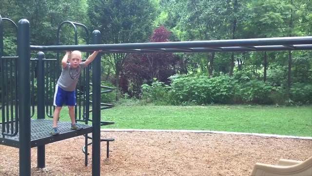 A Young Boy Does Monkey Bars And Falls In The End