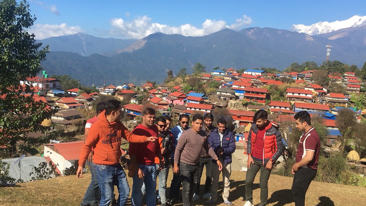 Youth dancing and a beautiful village in background