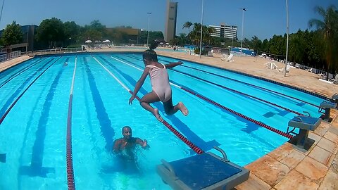 DUDA JUMPING OFF THE PLATFORM INTO THE SEMI-OLYMPIC SWIMMING POOL.